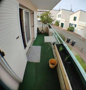 einen Balkon eines Hauses mit grünem Boden in der Unterkunft Cosy appart T4 90m~ Proche Paris - 5 min du RER C in Arpajon