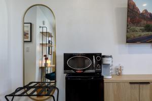 a microwave sitting on top of a refrigerator in a room at Quail Park Lodge in Kanab