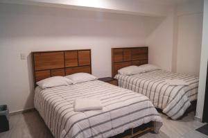 dwa łóżka w pokoju z białą pościelą w obiekcie Depto 5 Centro Expositor w mieście Puebla
