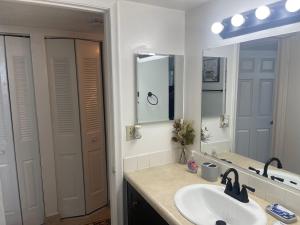 a bathroom with a sink and a mirror at Your Cozy Place in West Palm Beach