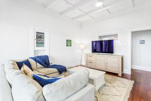 a living room with a couch and a tv at Spacious Kingsland 4BR Home in Auckland