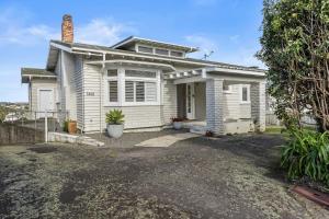een wit huis met een oprit ervoor bij Spacious Kingsland 4BR Home in Auckland