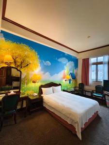 a hotel room with a bed and a painting on the wall at East Commercial Affairs Hotel in Luodong