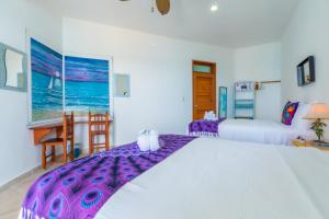 a bedroom with two beds and a table and a desk at Casa Cielo 2 Bedroom Oceanfront Villa in Isla Mujeres