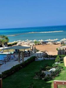 a resort with tables and umbrellas and a beach at Turtles beach resort in Hurghada