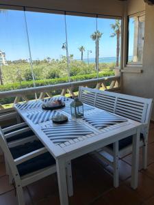 einen weißen Tisch auf einem Balkon mit Meerblick in der Unterkunft Primera Linea de Playa con Vistas al Mar in Isla Canela