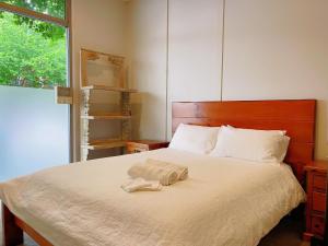 a bedroom with a bed with two towels on it at Newly renovated home in Auckland city in Auckland