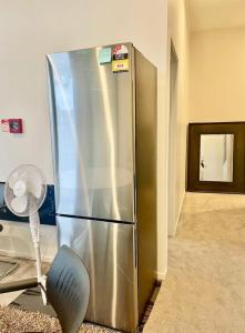 a stainless steel refrigerator in a room with a fan at Newly renovated home in Auckland city in Auckland
