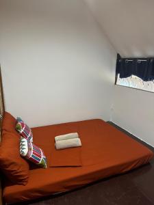 a orange couch with two towels on it in a room at HIRAYA Camp Site - FREE use of SCOOTER for NIPA HUTS in El Nido