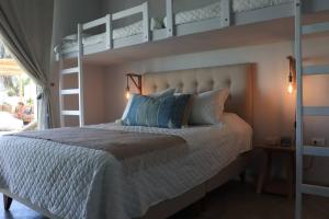 a bedroom with a bed with two bunk beds at Acogedora Casa en Condominio Oasis in Paracas