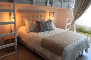 a bedroom with a white bed and a ladder at Acogedora Casa en Condominio Oasis in Paracas