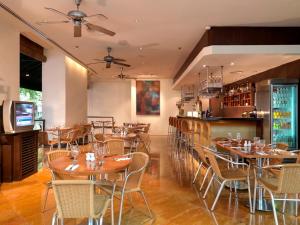 a restaurant with tables and chairs and a bar at Hotel Capitol Kuala Lumpur in Kuala Lumpur