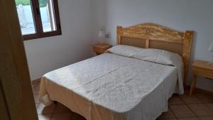 - une chambre avec un lit et une tête de lit en bois dans l'établissement Ferienwohnung für 6 Personen ca 80 qm in Pittulongu, Sardinien Gallura - b53984, à Olbia