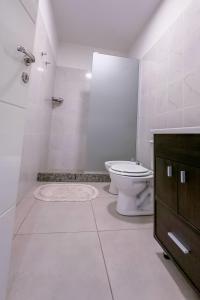 y baño blanco con aseo y ducha. en 659 Suites en San Juan