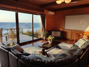 a living room with a couch and a large window at The Gold Beach House in Daisen