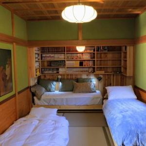 una camera con due letti e una libreria di The Gold Beach House a Kotoura