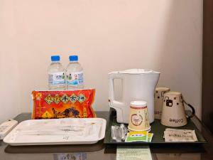 a counter with a coffee maker and bottles of water at East Commercial Affairs Hotel in Luodong