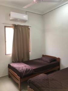 a bedroom with two beds and a window at Homestay Siti Klang in Klang