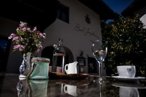 una mesa con una botella de vino y una copa en Waldhotel Bad Jungbrunn, en Tristach