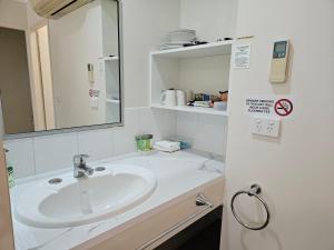 a bathroom with a sink and a mirror at Alstonville Settlers Motel in Alstonville