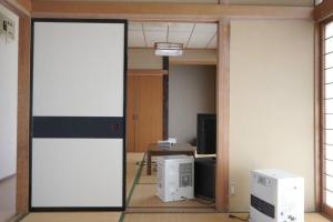 una habitación con una puerta que da a una habitación con cajas en 布施温泉ステイ　ウエスト en Saku