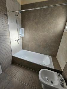 a bathroom with a tub and a sink at Azcuenaga Sur 2 in Guaymallen +12 photos