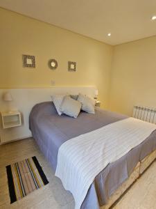 een slaapkamer met een groot bed met witte lakens bij Azcuenaga Sur 2 in Guaymallen +12 foto's