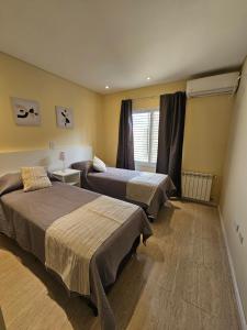 a bedroom with two beds and a window at Azcuenaga Sur 2 in Guaymallen