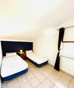 um quarto com duas camas e uma janela em Portimao Central Holiday Guesthouse em Portimão
