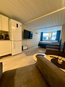 a living room with a couch and a refrigerator at studio apartment with parking in Lillehammer