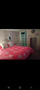 um quarto com um edredão vermelho numa cama em Hostal Familiar 2.0 em Chillán