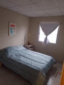 una camera con letto e finestra di Apart Los Laureles a Villa Regina