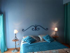 a blue bedroom with a bed with two lamps at Ancienne ferme rénovée au cœur de la Vallée Noire avec jardin clos, vélos et équipements complets - FR-1-591-111 in Tranzault