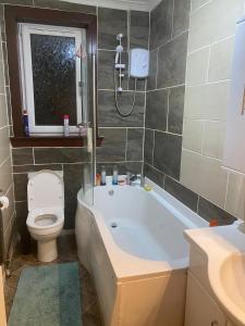 a bathroom with a tub and a toilet and a sink at Renton Residence in Renton