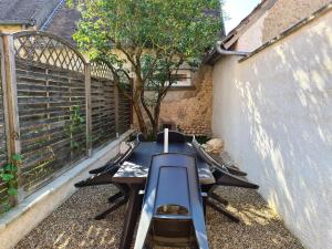 a patio with a bench and a table and a tree at Gîte 4 pers. avec terrasse privative entre Sologne et Châteaux de la Loire - FR-1-590-36 in Cléry-Saint-André
