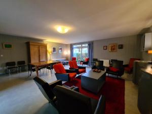 a living room with red chairs and a table at Gîte de charme en Berry avec jardin privatif, idéal pour randonnées et observation des oiseaux - FR-1-591-184 in Rosnay +11 photos