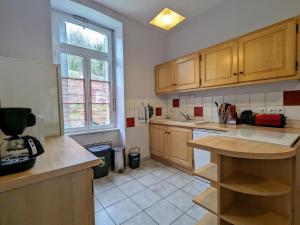 une cuisine avec des armoires en bois et un comptoir dans l'établissement Gîte confortable 3 chambres au bord de l'Allier - FR-1-582-16, à Saint-Julien-des-Chazes 15 autres photos