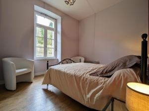 une chambre avec un lit, une fenêtre et une chaise dans l'établissement Gîte confortable 3 chambres au bord de l'Allier - FR-1-582-16, à Saint-Julien-des-Chazes
