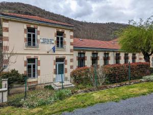 un vieux bâtiment avec un panneau à l'avant dans l'établissement Gîte confortable 3 chambres au bord de l'Allier - FR-1-582-16, à Saint-Julien-des-Chazes