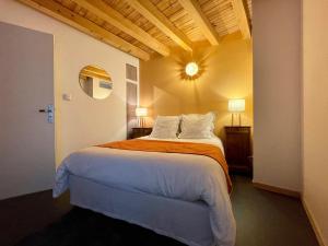 a bedroom with a large bed with an orange blanket at Gîte Polignac, 3 pièces, 4 personnes - FR-1-582-58 in Polignac