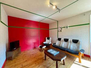 een woonkamer met een bank en een rode muur bij Gîte Retournac, 3 pièces, 4 personnes - FR-1-582-248 in Retournac