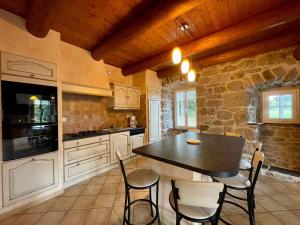 a kitchen with a table and chairs and a stone wall at Gîte Saint-Jeures, 5 pièces, 8 personnes - FR-1-582-254 in Saint-Jeures