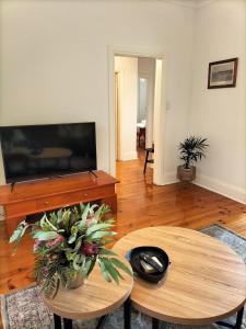 a living room with two tables and a flat screen tv at OXENBERRY FARM in McLaren Vale