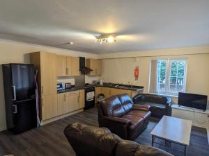 a living room with a couch and a kitchen at The Tiger - formerly Cassia Rooms in Worksop
