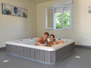 a man and woman sitting in a bath tub at Chalet Longeau-Percey, 3 pièces, 6 personnes - FR-1-611A-6 in Percey-le-Pautel