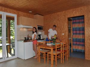 a man and a woman standing in a kitchen at Chalet Longeau-Percey, 3 pièces, 6 personnes - FR-1-611A-6 in Percey-le-Pautel