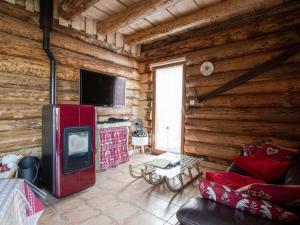 ein Wohnzimmer mit einem roten Kühlschrank in einer Blockhütte in der Unterkunft Gîte Anould, 4 pièces, 6 personnes - FR-1-589-378 in Anould