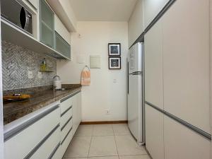 a kitchen with white cabinets and a refrigerator at Flat Confortável para Família ou a Trabalho, ao lado dos Ministérios e ESPLANADA, grande, completo, academia e no centro da cidade, em Saint Moritz Brasília Hotel in Brasília