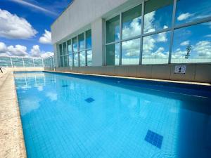 a large swimming pool in front of a building at Flat Saint Moritz Brasília Hotel in Brasilia