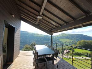 a wooden deck with a table and chairs on a balcony at Chalet à La Bresse avec cheminée et garage - FR-1-589-385 in La Bresse